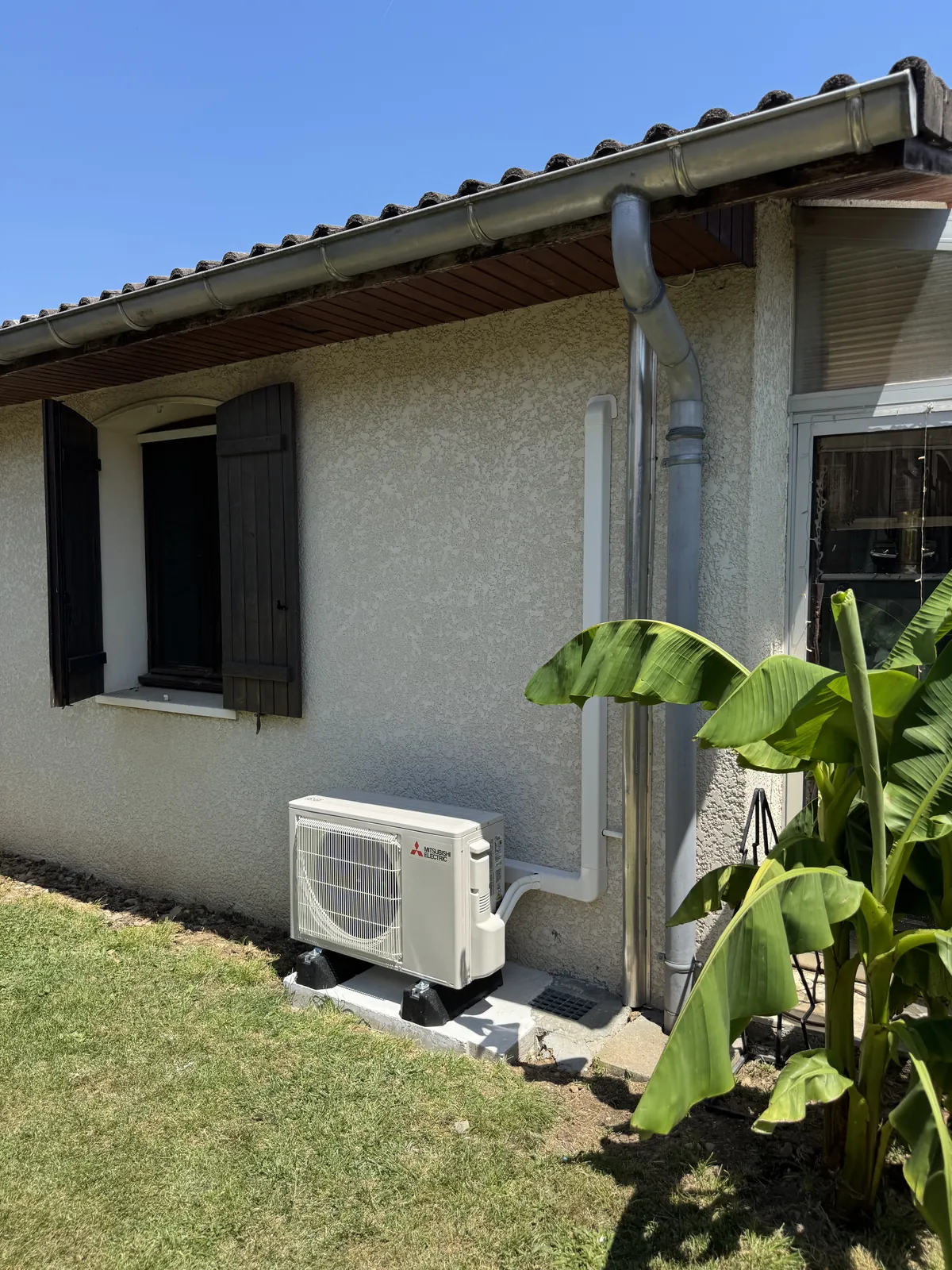 Unité extérieure de climatisation au pied d’une maison